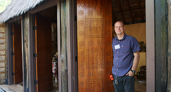 Photo of David Duffin, Facilities Planning Manager at the Polynesian Cultural Center shows the beautiful machine milled wood doors in the Fijian Village courtesy of Mike Foley