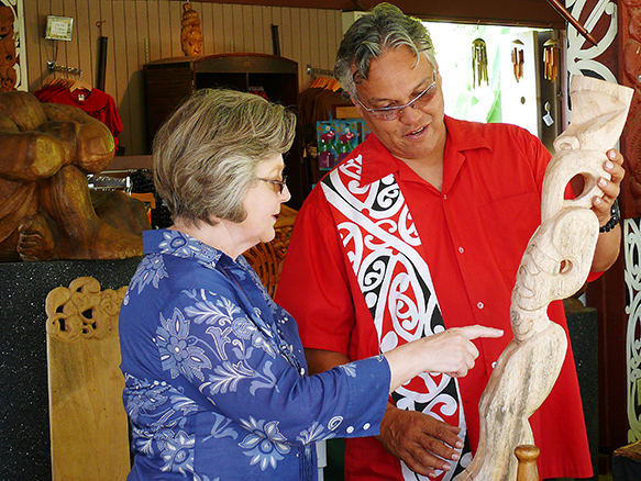 Doug Christy shows guest a carving that he is currently working on