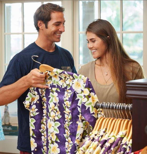 Two people shopping for aloha shirts at Nona's Tropical Threads