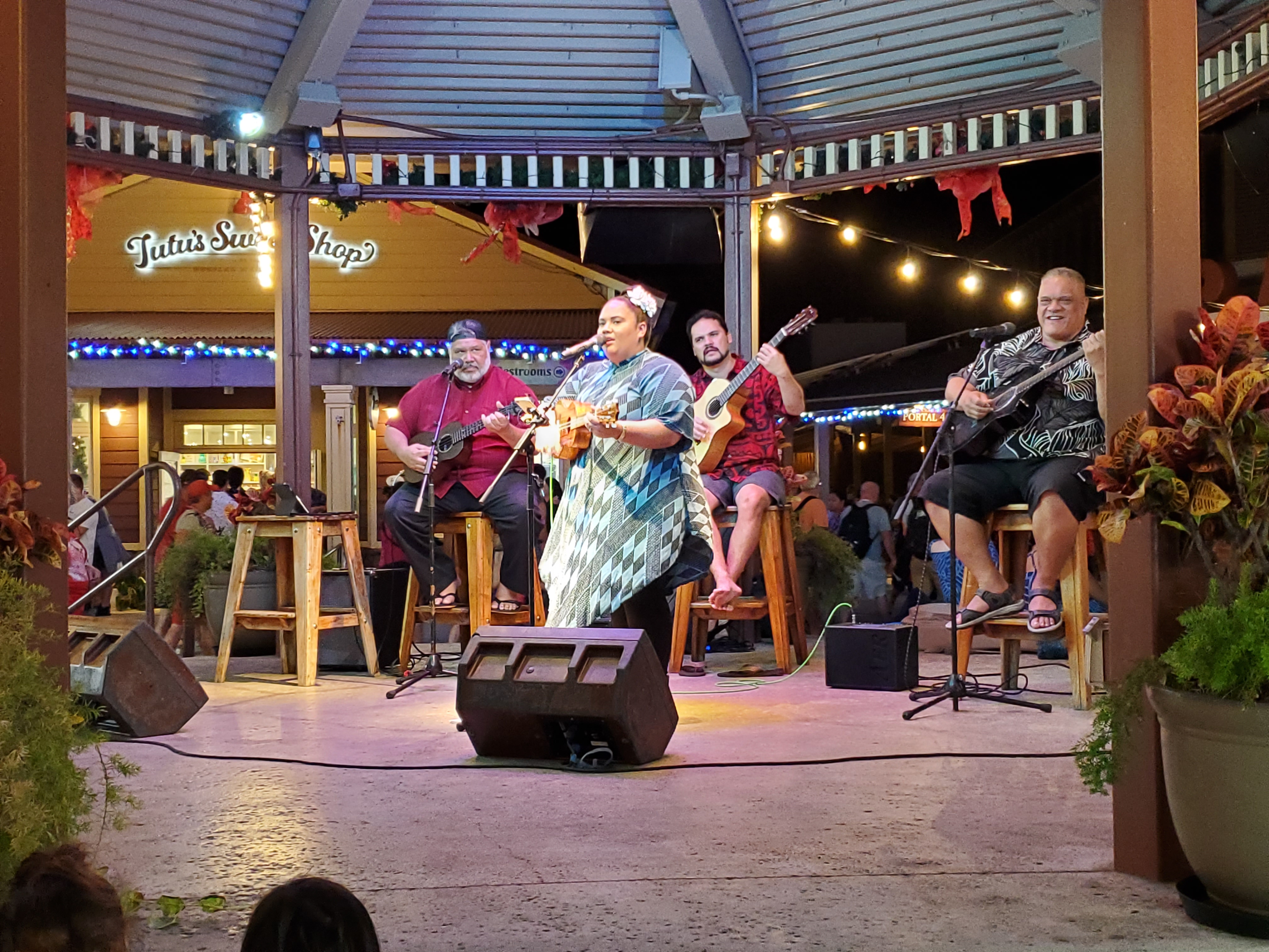 Photo showcasing entertainment from the gazebo in the Hukilau Marketplace's center Gazebo, featuring (insert name of musicians)