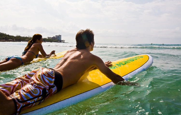 Photo of man and woman surfing at Waikiki courtesy of the Hawaii Tourism Authority/ Tor Johnson