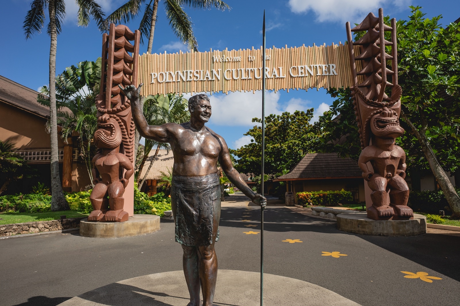 photo of bronze statue of Hamana Kalili and two hand carved tiki statues at the Polynesian Cultural Center