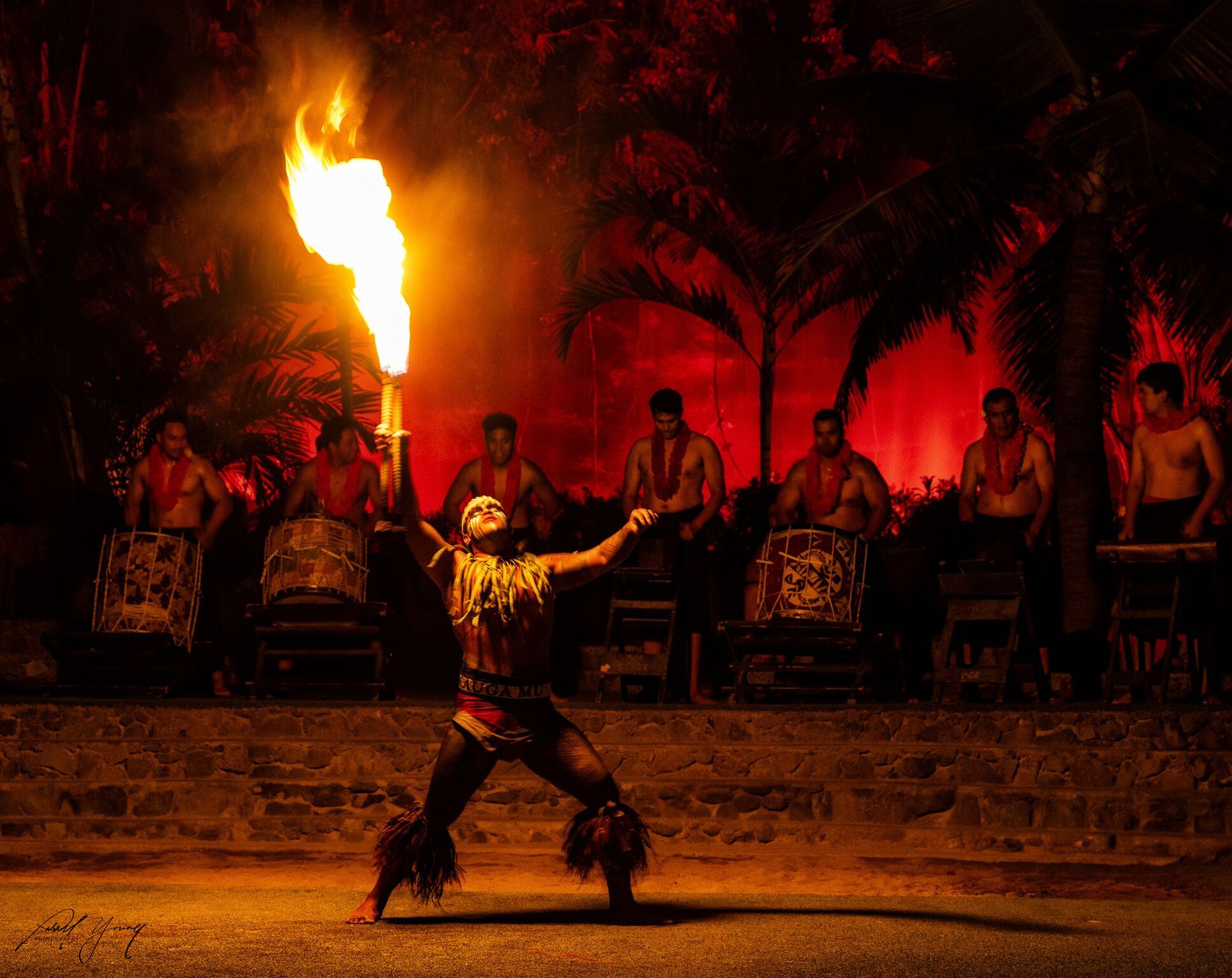photograph of competitor at the Polynesian fireknife dancer performing at the 27th Annual Fireknife Co with drummers playing in the backgroun.petition