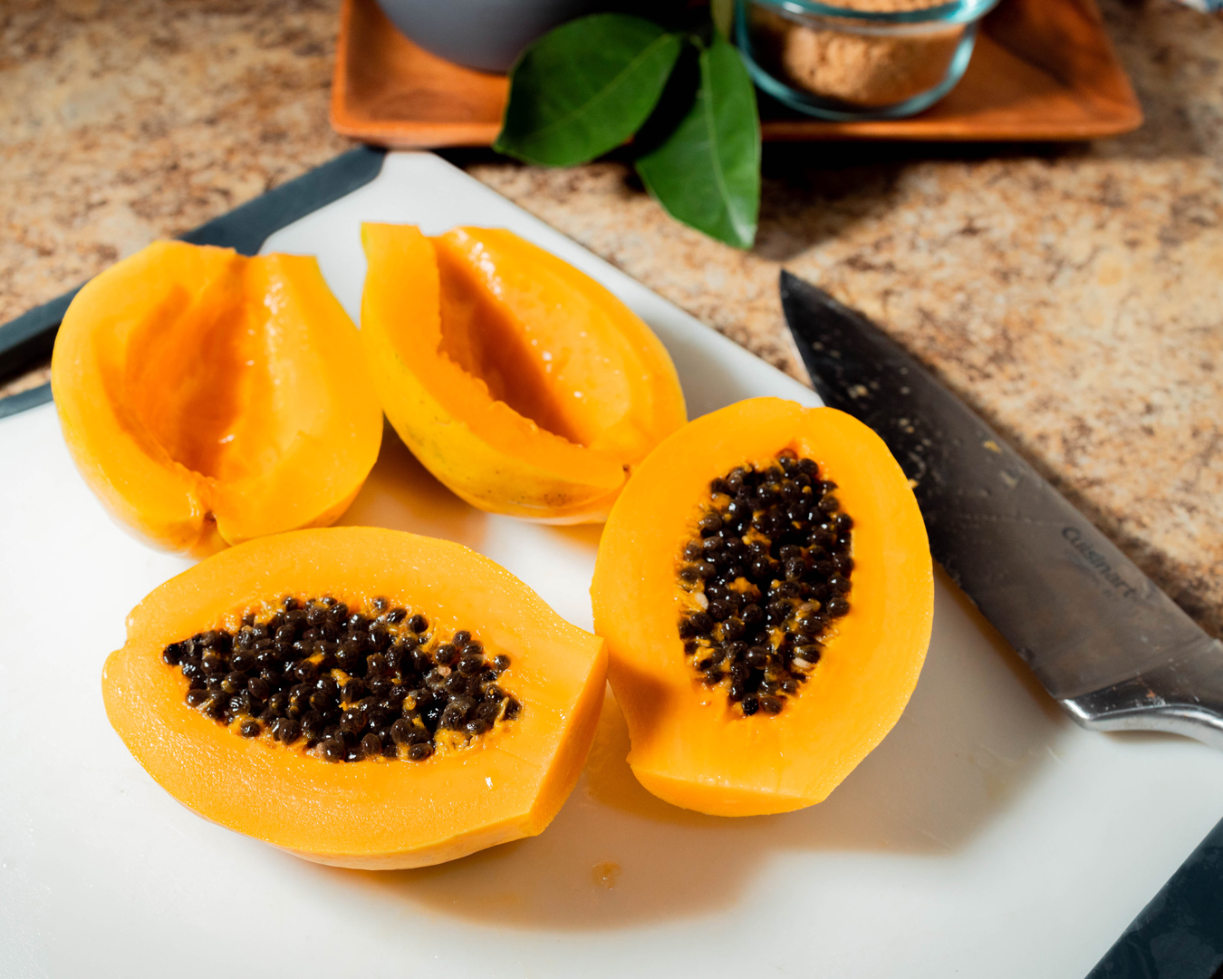 To prepare the papayas, cut them in halves and use a spoon to remove the seeds.