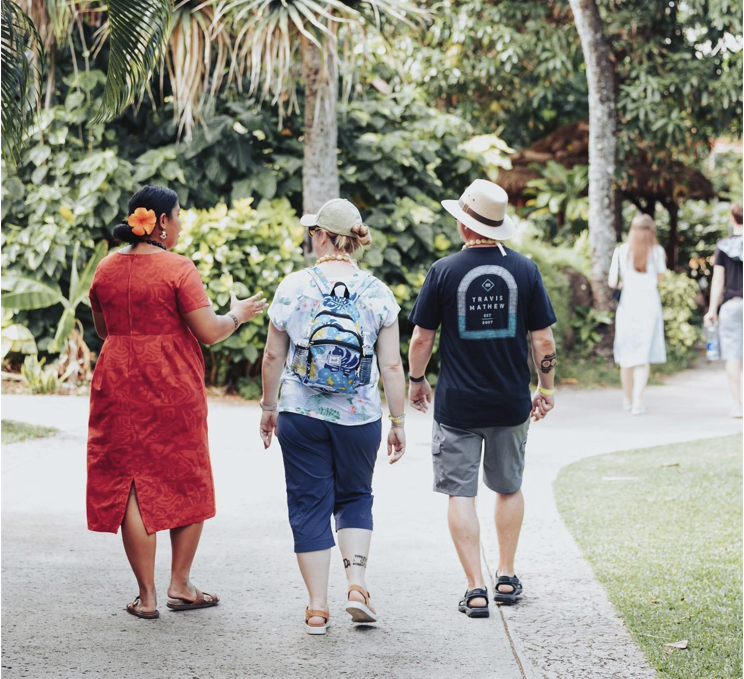 photo of a tour guide giving a tour to a couple visiting the Polynesian Cultural Center