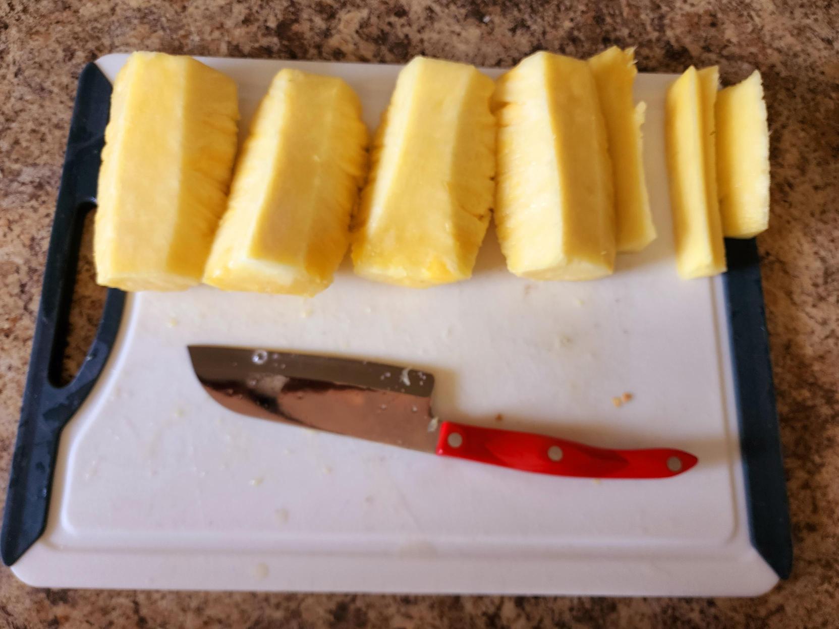photo of pineapple in 4 halves with each stem on the right side. 