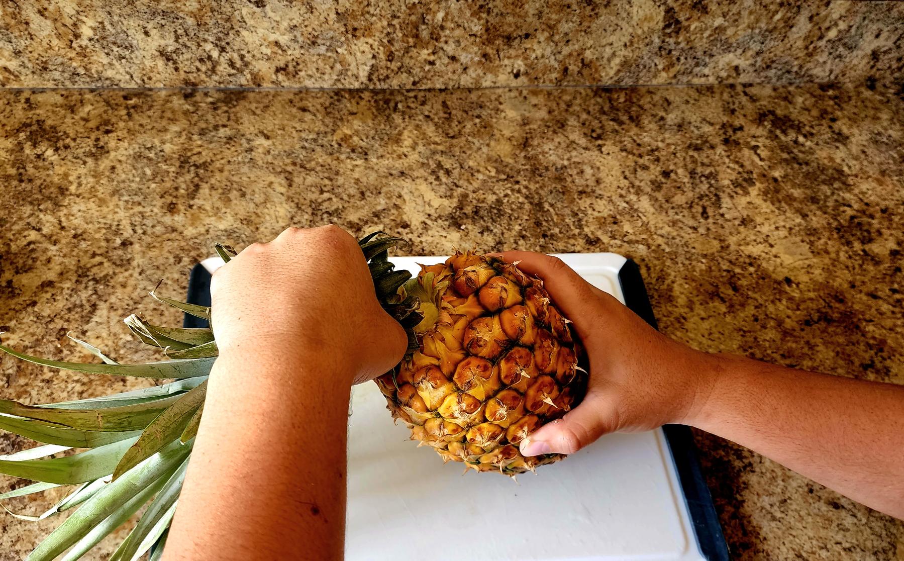 Photo of removing the flower from the whole pineapple. Get ready to prepare your vaifala (pineapple drink). 
