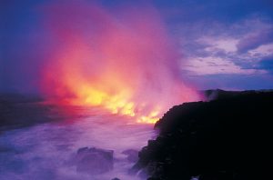 Hot lava hitting the ocean near the Big Island shoreline at dusk