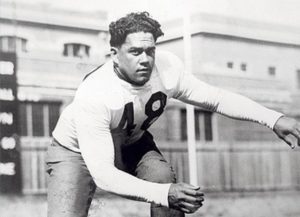 black and white photo of Harry Montague Field wearing long-sleeve football pads in a crouching pose