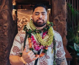 Manti Te'o strikes a shaka pose while wearing authentic Hawaiian leis and a shirt at the 2023 Polynesian Football Hall of Fame.