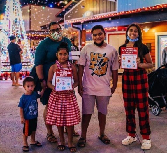 Happy family at Hukilau Marketplace showing their scavenger hunt cards