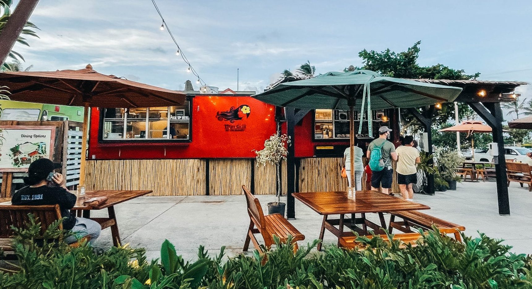 Tita's Grill, a bright red food truck with seating around it