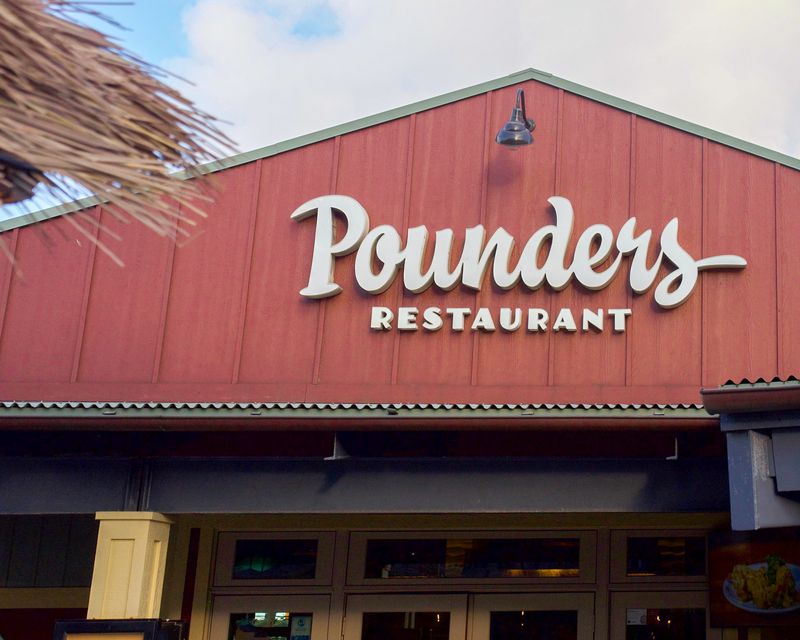 The white sign on red wood above the door of Pounders Restaurant