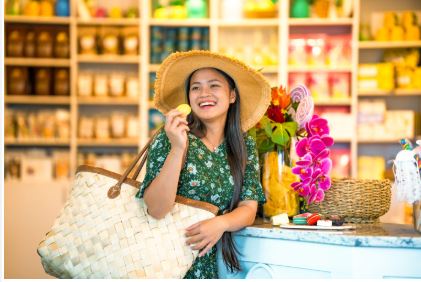 Young woman in green dress and big, floppy hat enjoying a treat at Tutu's