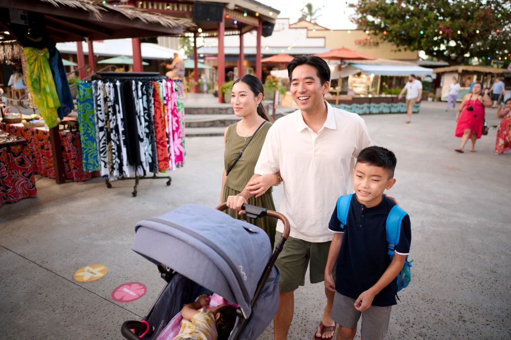 Asian parents with young son and infant shopping outdoors