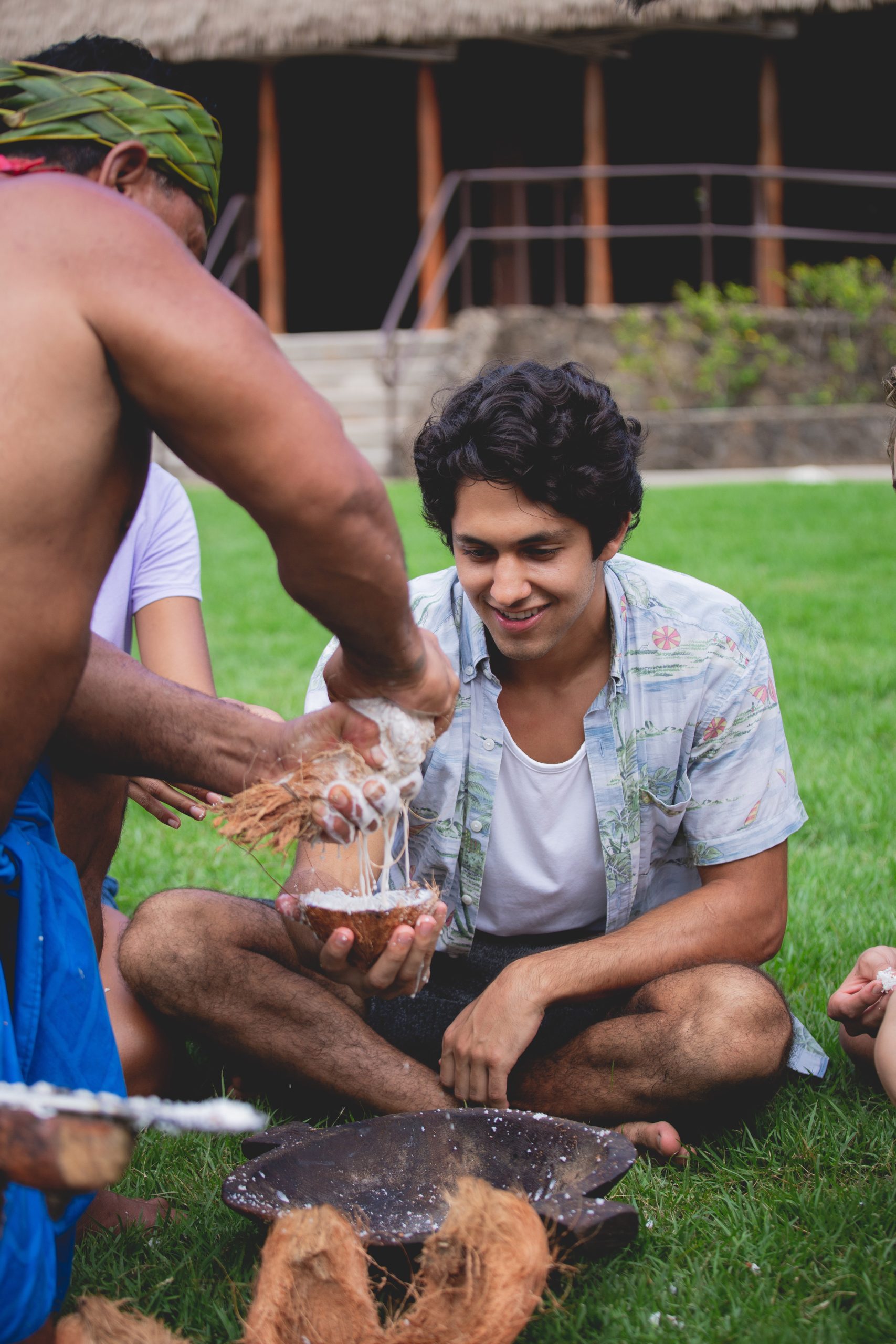 Samoan presenter shares coconut milk straight from the coconut with a male guest.