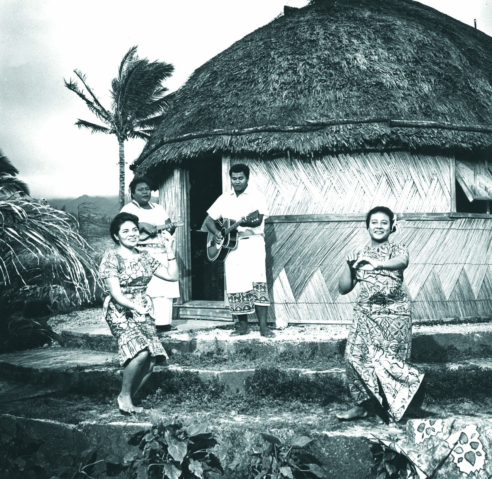 Tongan grass hut with musicians and dancers in native costume