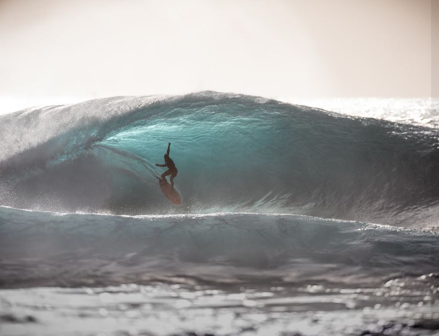 Surfer shooting the curl at Pupukea, Oahu North Shore.