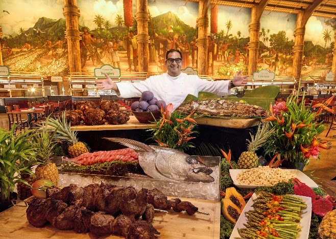 Chef presenting the myriad of foods available at his buffet.